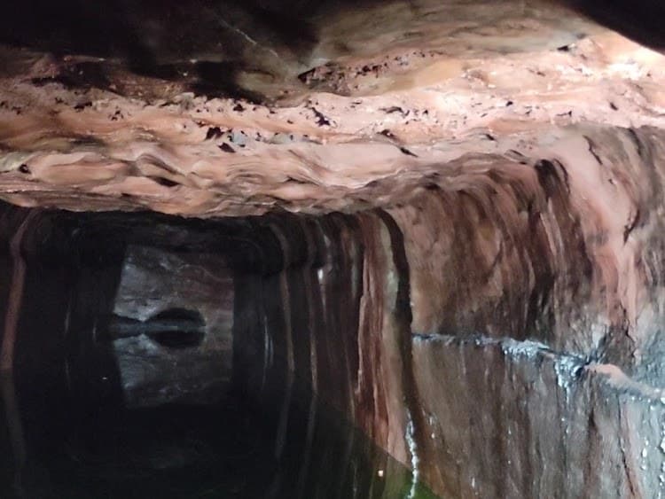 Pink salt tunnel with brine reflection inside Khewra Salt Mine